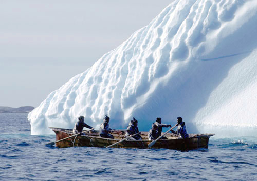 Konebåd fra Nanortalik der sejler tæt forbi et isfjeld